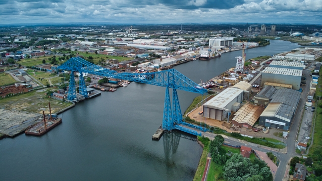 A drone picture of the port of Middlesborough with Teesside in the background, a large blue transporter bridge is in the foreground
