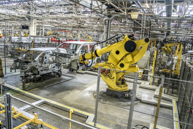 A picture of a yellow robot assembling small vans at the Stellantis factory in Ellesmere Port