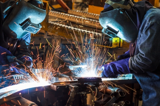 worker with protective mask welding metal